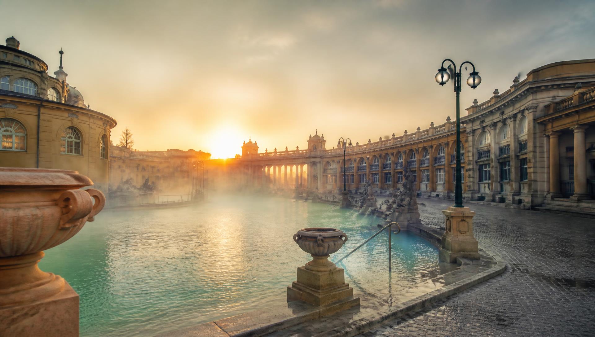 Steam rising from a historic thermal bath at dawn