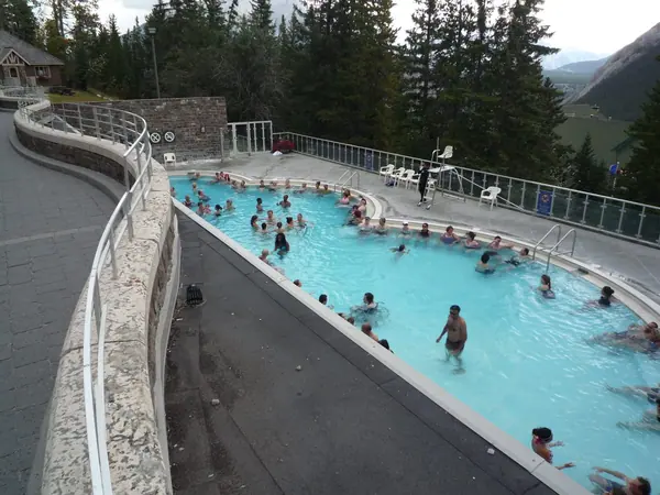 Outdoor thermal pool at Banff Upper Hot Springs below forested mountain slopes