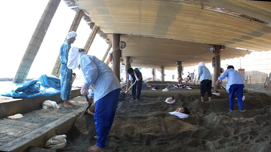 Bathers buried in hot volcanic sand on the beach at Ibusuki