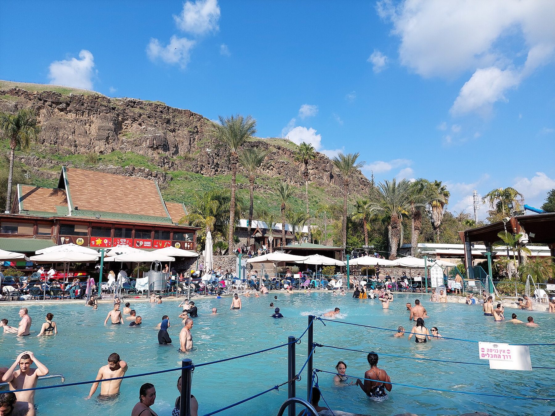 Bathers in the open thermal pools at Hamat Gader below the valley slope