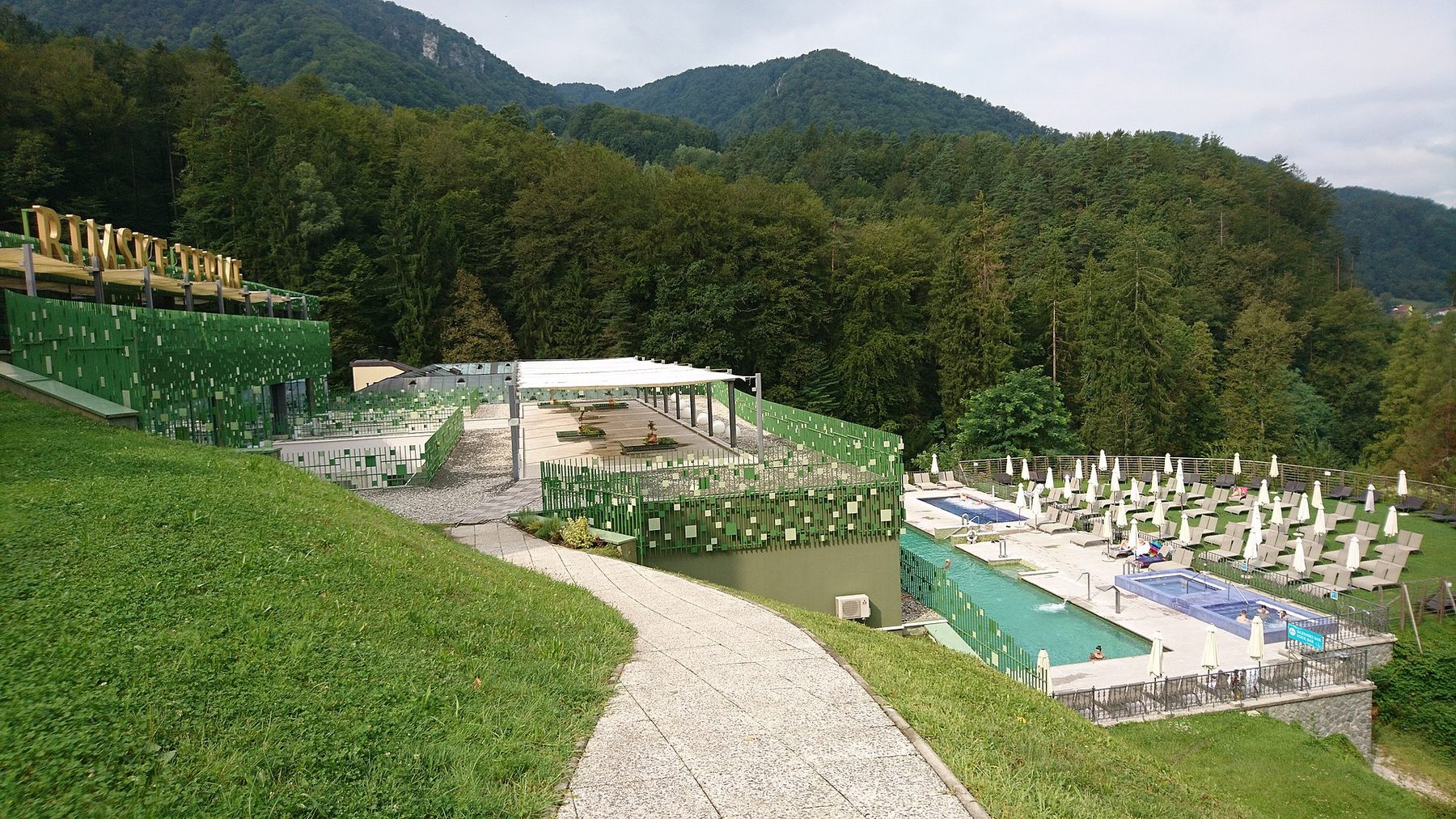 Terraced outdoor thermal pools on the wooded hillside at Rimske Terme