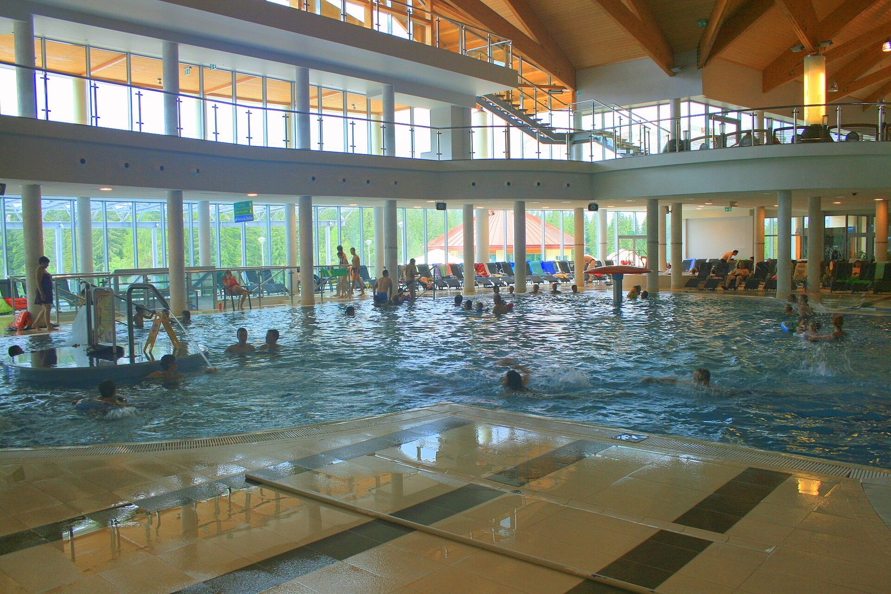 Indoor geothermal pool hall with glass walls at Terma Bukovina